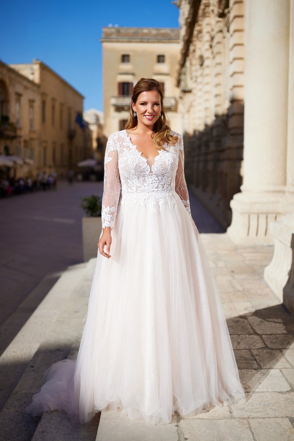 Brautkleid curvy von Tres Chic mit langen Ärmeln aus Spitze. Brautkleider Tres Chic 2025. Die Top-Trends für Curvy-Brautmode 2025. Brautmode curvy bei Biancas Brautmoden in Bad Kreuznach kaufen. Riesige Auswahl an Brautkleidern in großer Größe. Viele Curvybrautkleider haben lange Ärmel in verschiedenen Styles. Curvybräute lieben Brautkleider mit Ärmel um ihre Arme zu bedecken. Brautkleid currvy A-Linie mit langen Ärmeln. Brautkleider Tres Chic für deine Hochzeit 2025 in Bad Kreuznach, in der Nähe, in Mainz, in Wiesbaden, in Koblenz, in Mannheim kaufen.