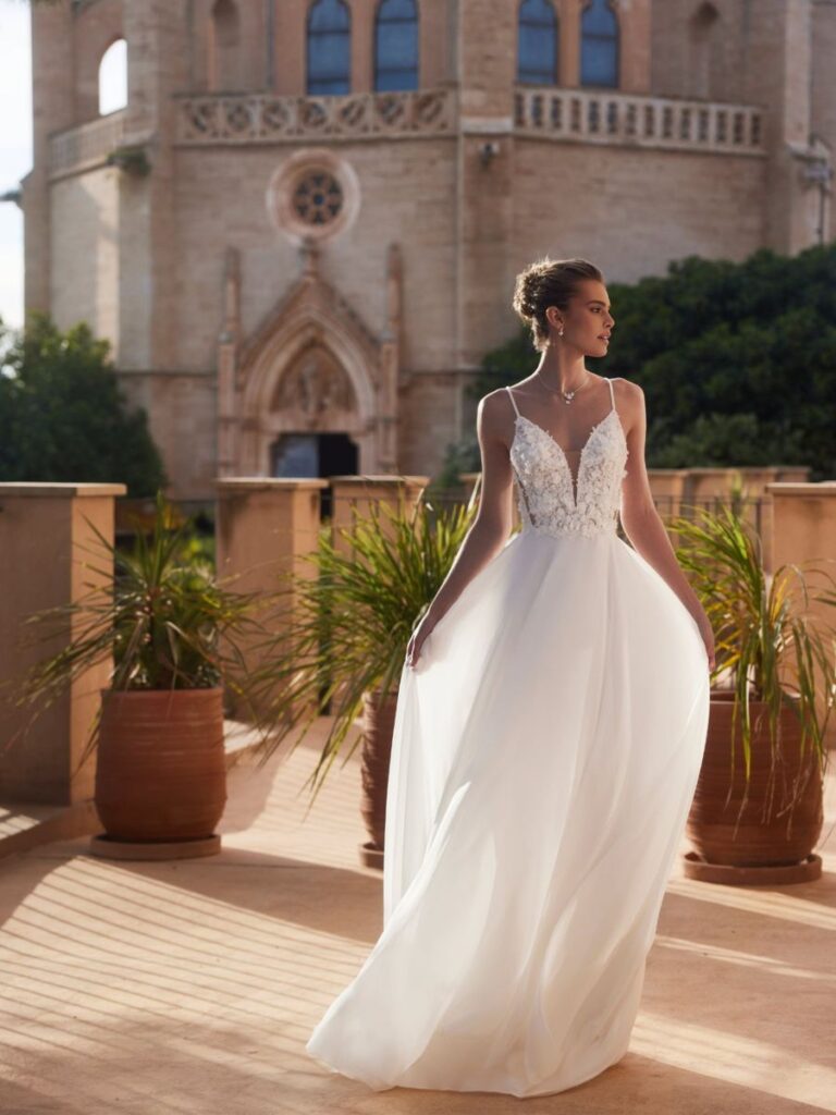Leichtes Brautkleid mit Spitzenoberteil und tiefem V-Ausschnitt, fließender Chiffonrock in A-Linie – erhältlich bei Bianca’s Brautmoden.