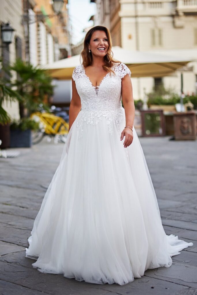 Curvy Brautkleid 2026 mit V-Ausschnitt, Spitzen-Corsage und weitem Tüllrock von Bianca’s Brautmoden