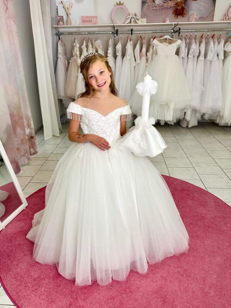 Kommunion 6 Kommunionkleid in Ivory mit Perlenverzierung und schulterfreiem Ausschnitt – italienisches Design für die Kommunion 2026, erhältlich bei Bianca’s Brautmoden Bad Münster.