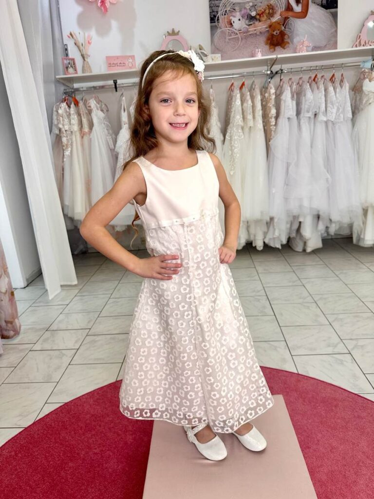 Kommunion 45 Kommunionkleid in Ivory mit floraler Spitze und modernem A-Linien-Schnitt – elegantes Modell für Kommunion 2026, erhältlich bei Bianca’s Brautmoden Bad Münster.