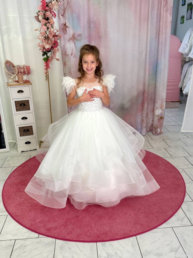 Kommunion 2 Kommunionkleid in Weiß mit Perlenoberteil, Federträgern und Glitzertüll – pompöses Prinzessinnenkleid für Kommunion 2026, erhältlich bei Bianca’s Brautmoden Bad Münster.
