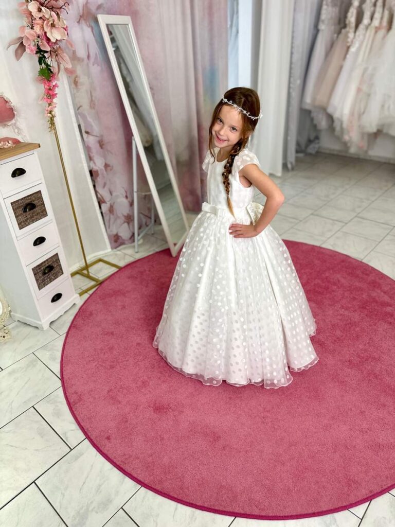 Kommunion 40 Kommunionkleid in Weiß mit Punktetüll, Flügelärmeln und Taillenschleife – festliches Kleid für Kommunion 2026, erhältlich bei Bianca’s Brautmoden Bad Münster.