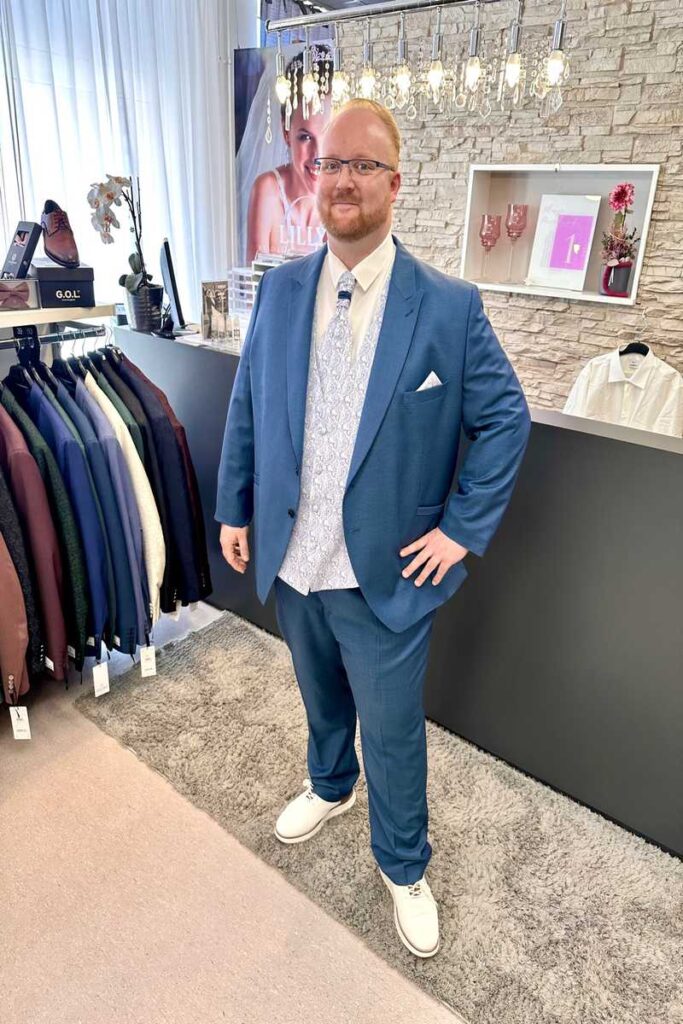 Mann mit großer Größe im Anzug von Wilvorst mit WEste.