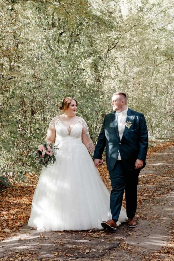 Curvy Braut in ihrem Brautkleid in Übergröße an ihrer Hochzeit. Mann mit Übergröße im Anzug 7xl von Wilvorst