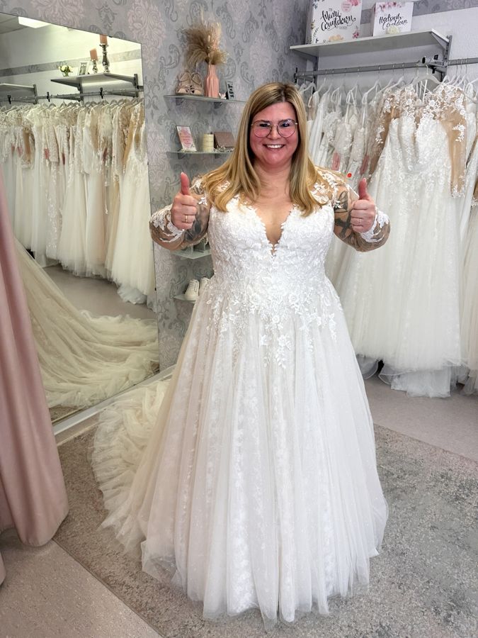 Glückliche Curvybraut beim Abholen ihres Brautkleides in großer Größe