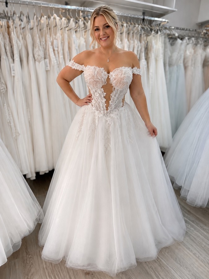 Braut in einem raffinierten Corsagenbrautkleidern in Off-Shoulder und Stäbchenoptik.