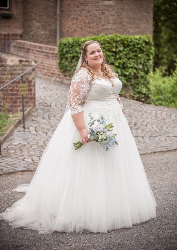 Curvybraut in einem romantischen Brautkleid Gr. 58 mit langen Spitzenärmeln.