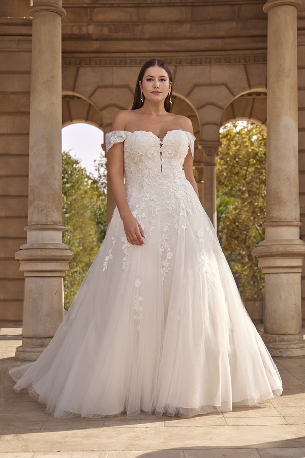 Curvy Brautkleid in A-Linie mit Carmen-Ausschnitt, floraler Spitze und Tüllrock aus der Kollektion 2027 bei Bianca's Brautmoden Bad Kreuznach