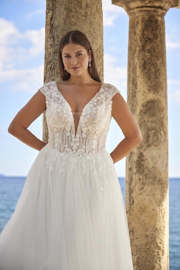 Curvy Brautkleid in A-Linie mit floraler Spitze, V-Ausschnitt und zarten Flügelärmeln aus der Kollektion 2027 bei Bianca's Brautmoden Bad Kreuznach